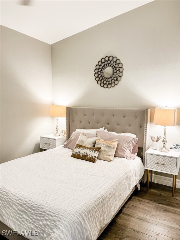 bedroom with dark hardwood / wood-style floors