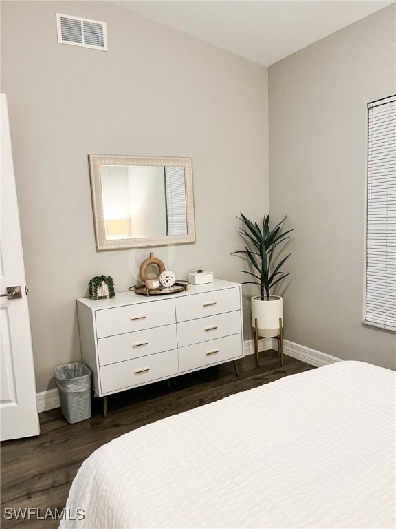 bedroom with dark hardwood / wood-style floors