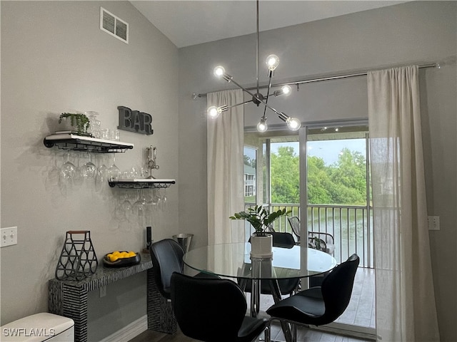 dining space with hardwood / wood-style flooring and an inviting chandelier