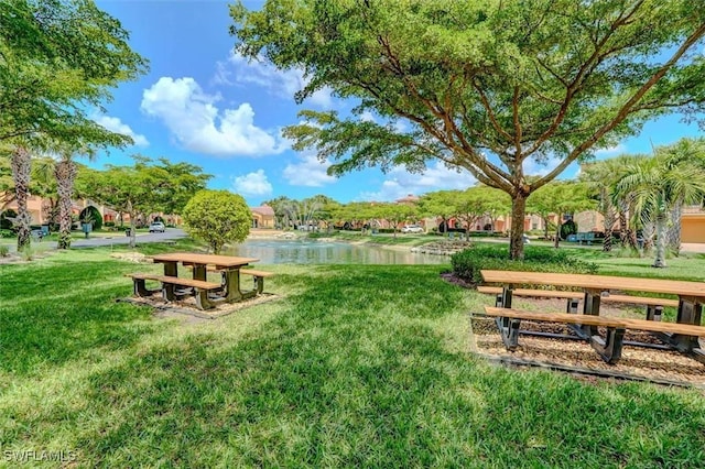 surrounding community featuring a lawn and a water view