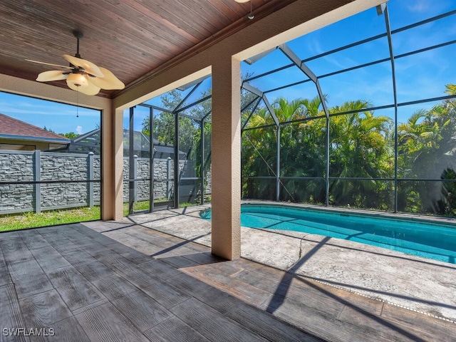 view of pool with glass enclosure, ceiling fan, and a patio area