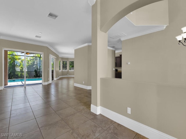 empty room with ornamental molding and light tile patterned flooring