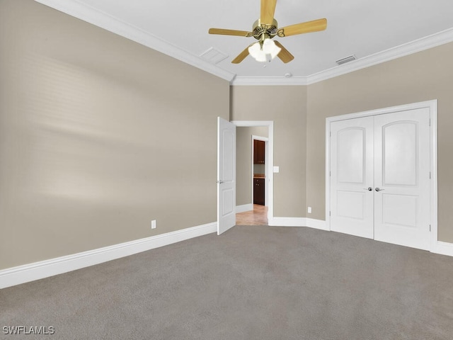 unfurnished bedroom with carpet, ornamental molding, ceiling fan, and a closet