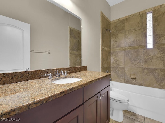 full bathroom with tile patterned flooring, tiled shower / bath combo, vanity, and toilet