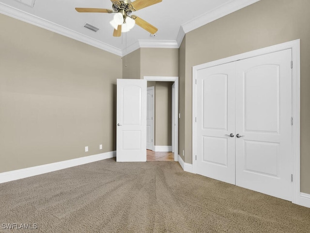 unfurnished bedroom featuring ceiling fan, a closet, ornamental molding, and carpet