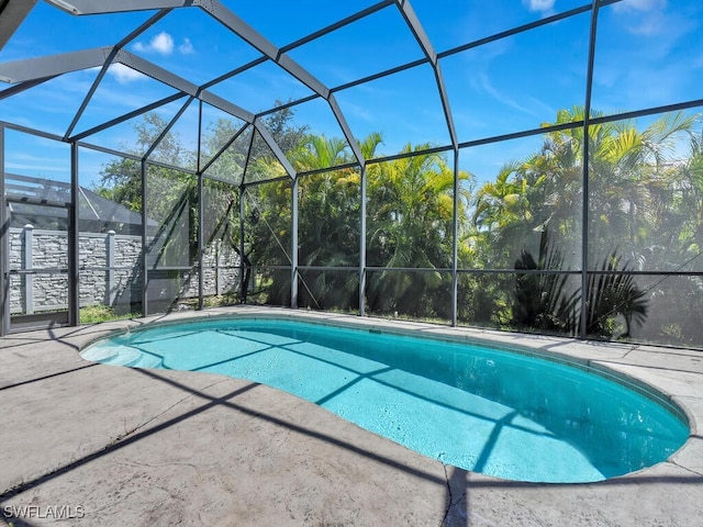 view of swimming pool featuring a lanai and a patio