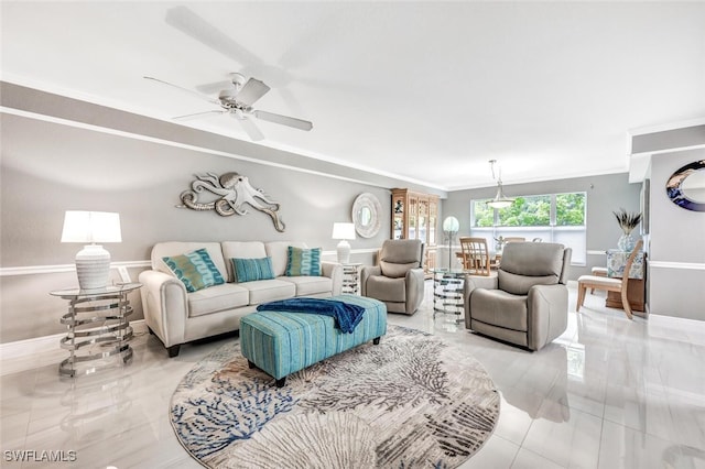 tiled living room with ceiling fan and ornamental molding