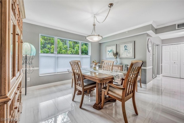 tiled dining space featuring crown molding