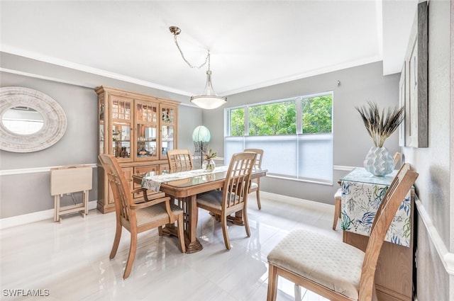 dining space with ornamental molding and light tile patterned floors