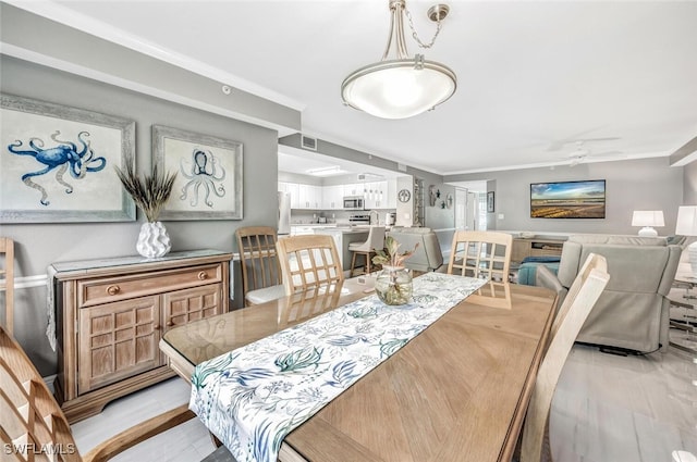 dining space with ceiling fan and light hardwood / wood-style flooring