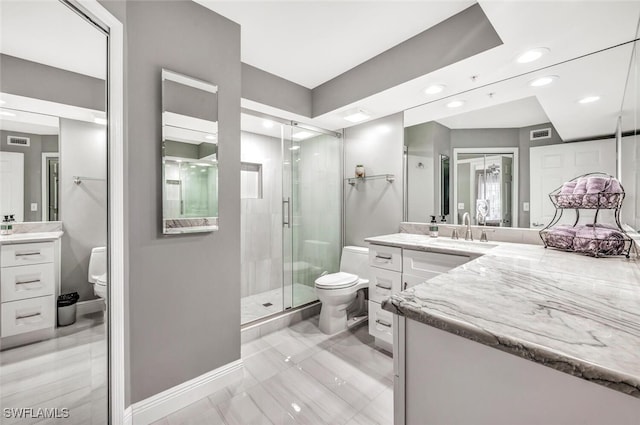 bathroom featuring an enclosed shower, vanity, and toilet