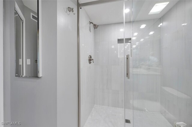 bathroom featuring a shower with door