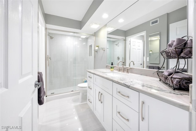 bathroom with vanity, toilet, a shower with door, and tile patterned floors