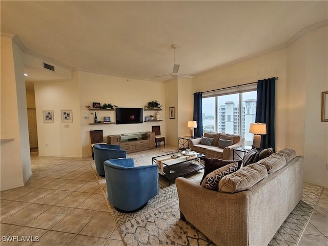 living area featuring light tile patterned floors, ceiling fan, visible vents, baseboards, and ornamental molding