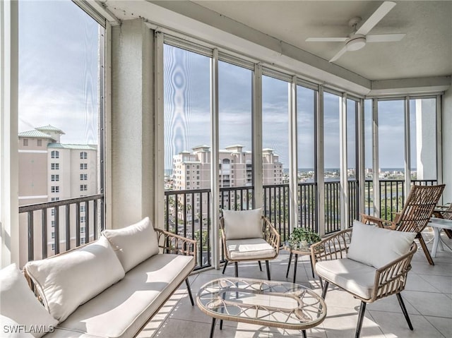 sunroom / solarium featuring a ceiling fan and a city view