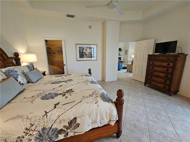 bedroom featuring light tile patterned flooring, a towering ceiling, visible vents, a spacious closet, and a closet