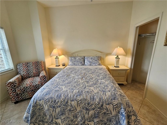 bedroom featuring a closet, baseboards, and light tile patterned floors