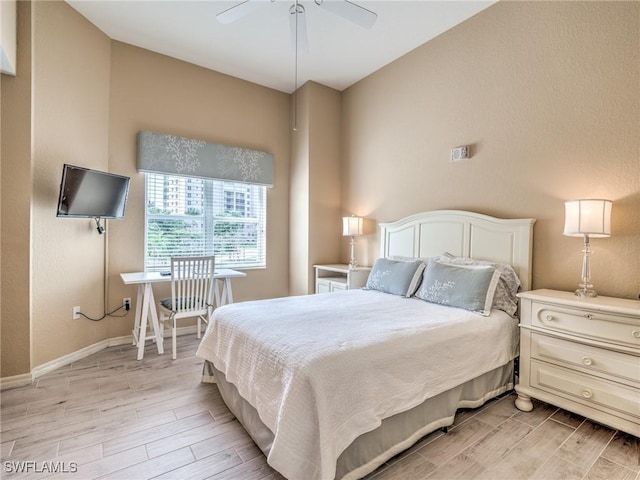 bedroom with light wood finished floors, a ceiling fan, and baseboards