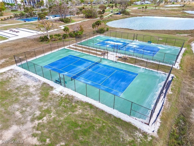 view of sport court with a water view and fence