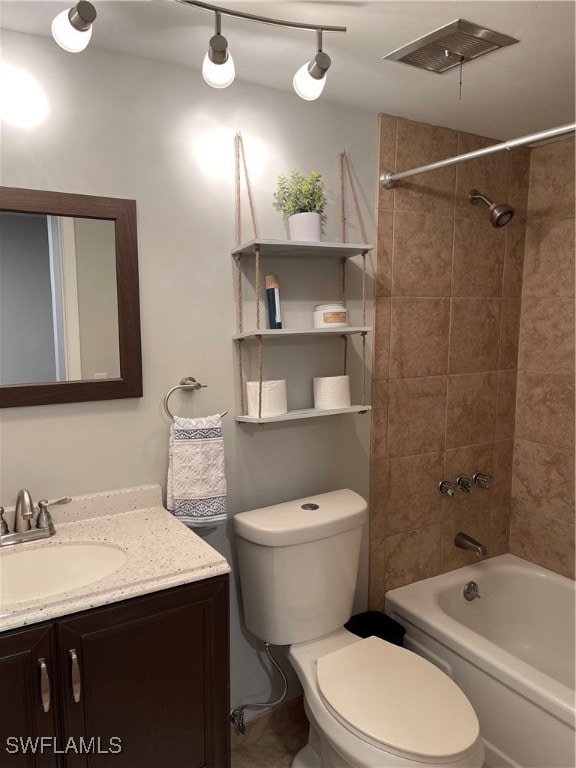 full bathroom with tiled shower / bath, vanity, and toilet