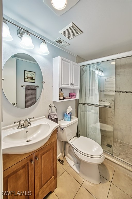 bathroom with tile patterned floors, vanity, an enclosed shower, and toilet