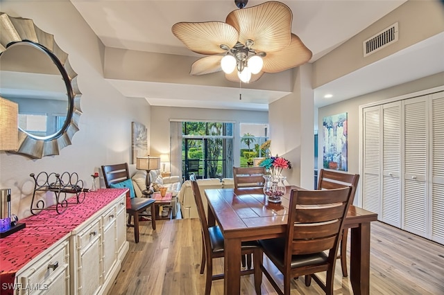 dining space with light wood-type flooring and ceiling fan