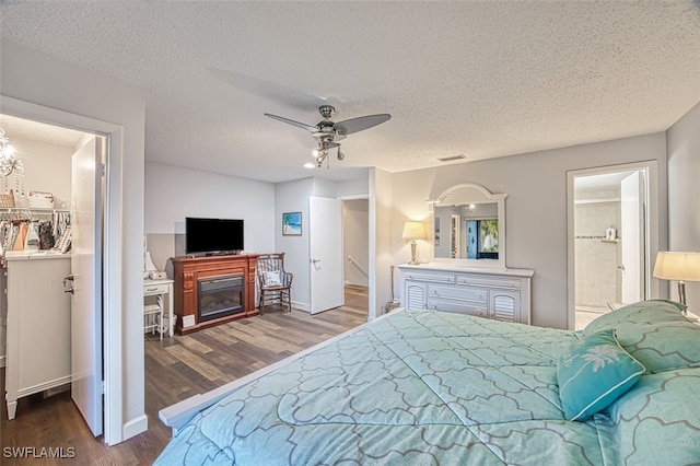 bedroom with a textured ceiling, ceiling fan, ensuite bathroom, and a closet