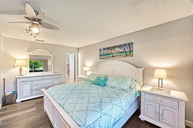 bedroom featuring ceiling fan, dark hardwood / wood-style floors, and a textured ceiling