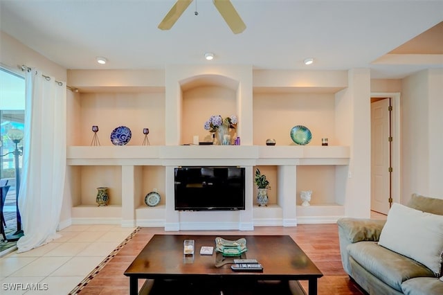 living room with ceiling fan, hardwood / wood-style flooring, and built in features