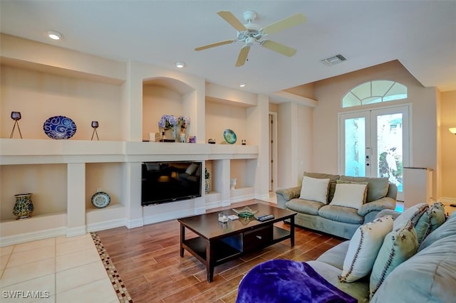 living room with wood-type flooring, french doors, built in shelves, and ceiling fan