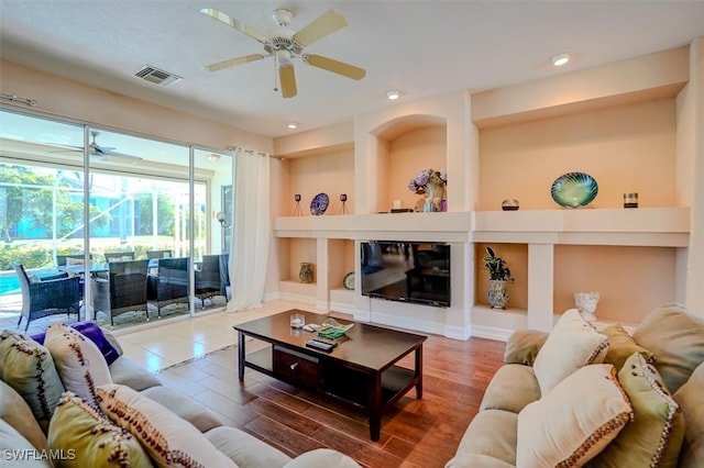 living room with wood-type flooring and ceiling fan