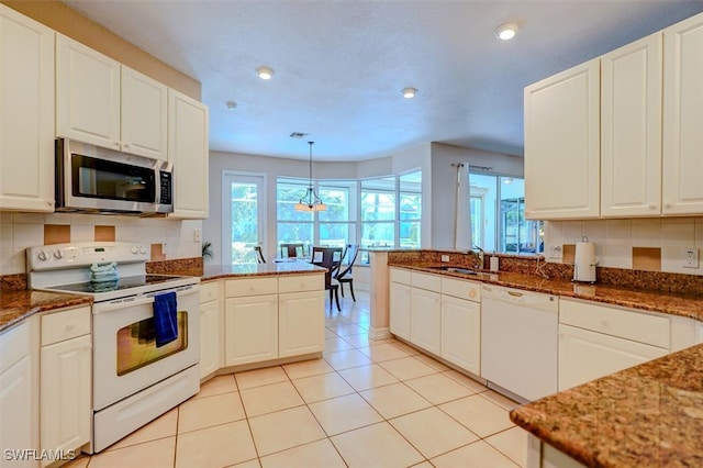 kitchen with hanging light fixtures, white appliances, tasteful backsplash, and white cabinets