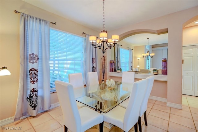 tiled dining area featuring a chandelier