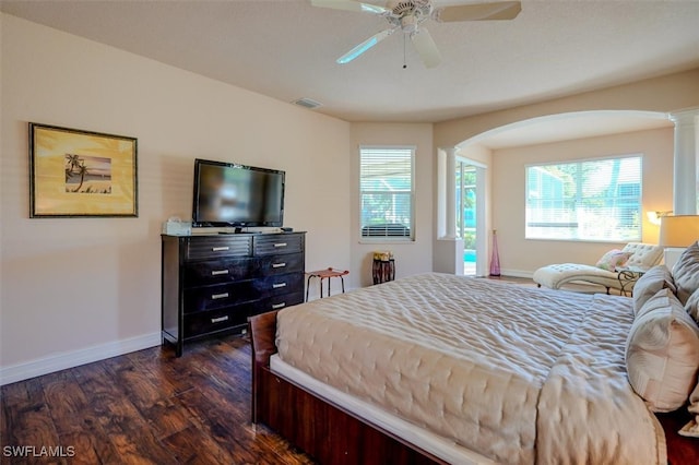 bedroom with dark hardwood / wood-style flooring, ceiling fan, and ornate columns