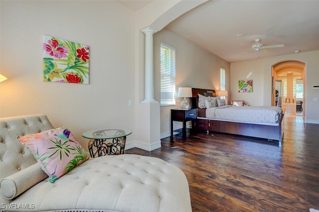 bedroom with decorative columns, dark hardwood / wood-style floors, and ceiling fan