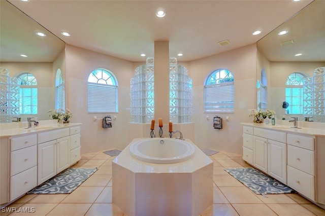 bathroom featuring vanity, tile patterned floors, and a relaxing tiled tub