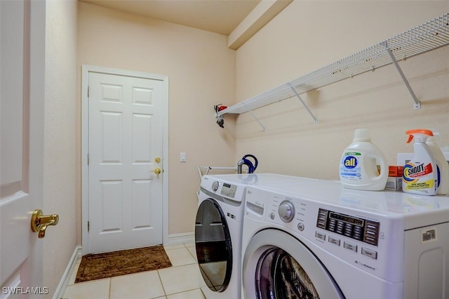 laundry area featuring light tile patterned floors and washer and clothes dryer