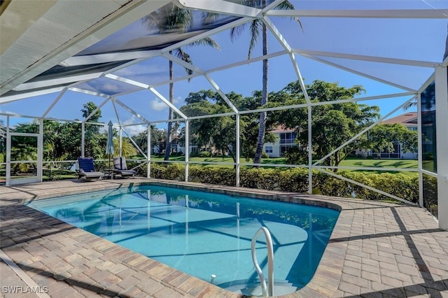 view of pool with glass enclosure and a patio