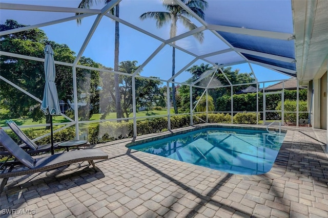 view of pool featuring glass enclosure and a patio