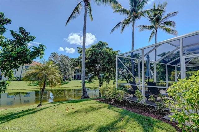 view of yard with a water view and glass enclosure