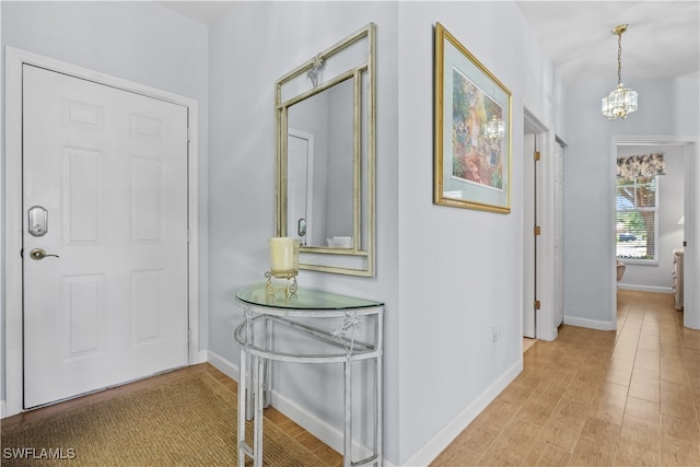 interior space with a notable chandelier and light wood-type flooring