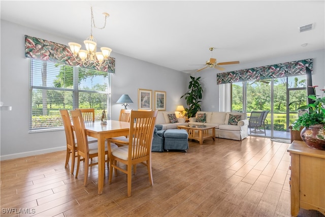 dining room with ceiling fan with notable chandelier and a healthy amount of sunlight