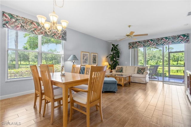 dining space with ceiling fan with notable chandelier and plenty of natural light