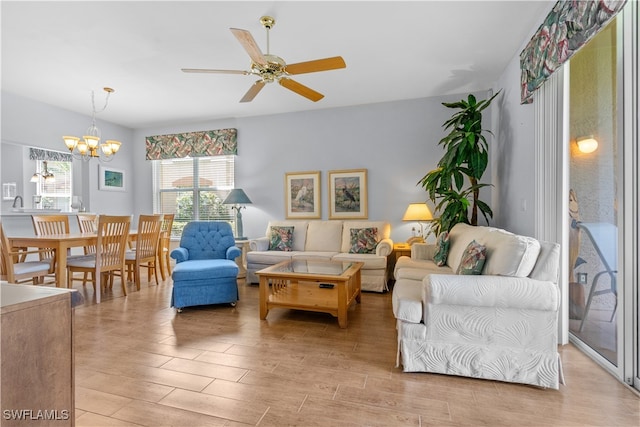 living room featuring ceiling fan with notable chandelier