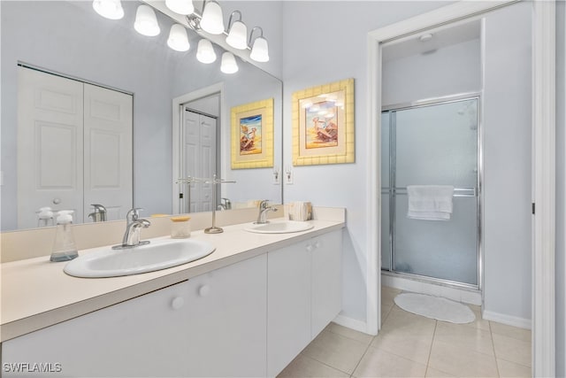 bathroom with tile patterned floors, a shower with shower door, and vanity