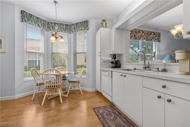 kitchen with a chandelier, white dishwasher, white cabinetry, and pendant lighting