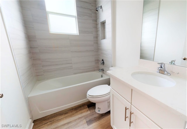 full bathroom featuring wood-type flooring, vanity, toilet, and tiled shower / bath