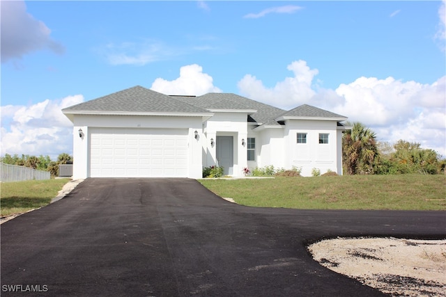 view of front of home with a garage, central air condition unit, and a front yard