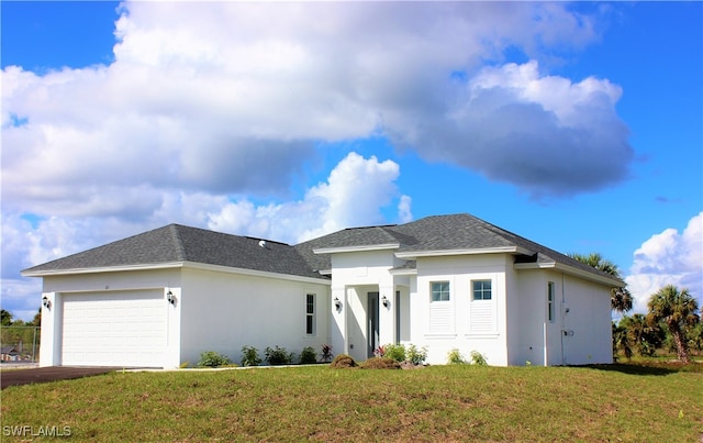 prairie-style house featuring a garage and a front lawn