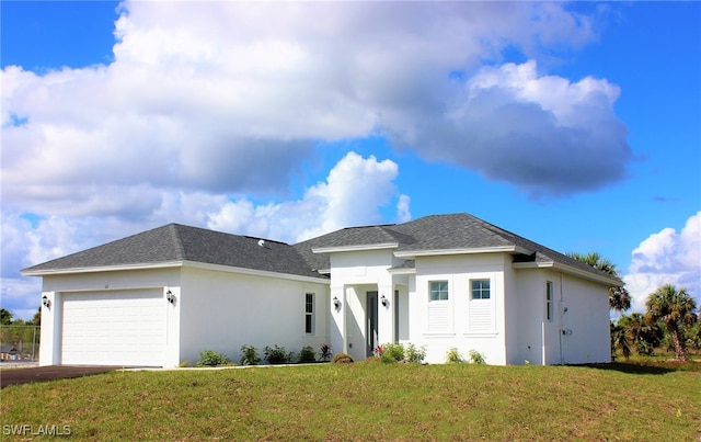 prairie-style home with a front yard and a garage